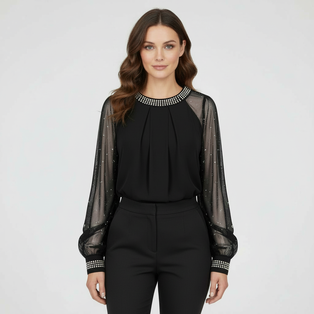 Female model wearing a mesh top with sequin detailing and long sleeves against a plain background.
