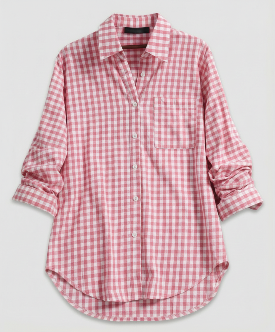 Woman wearing a timeless plaid blouse with long sleeves against a plain backdrop.