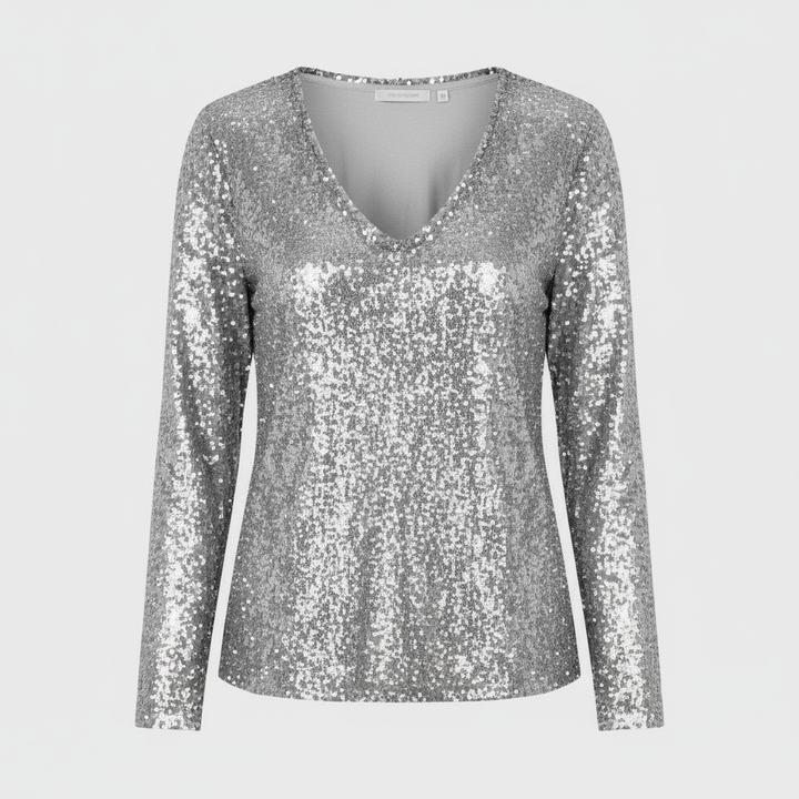 Woman in a sparkling party top paired with a simple plain backdrop.
