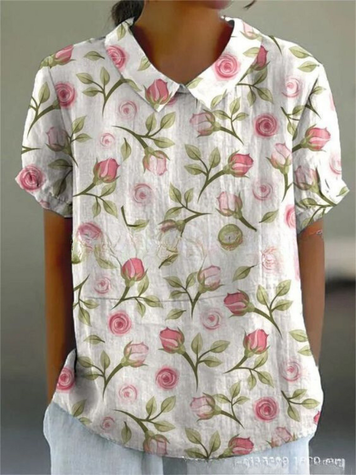  Woman wearing a floral print blouse designed for casual styling on a plain background.