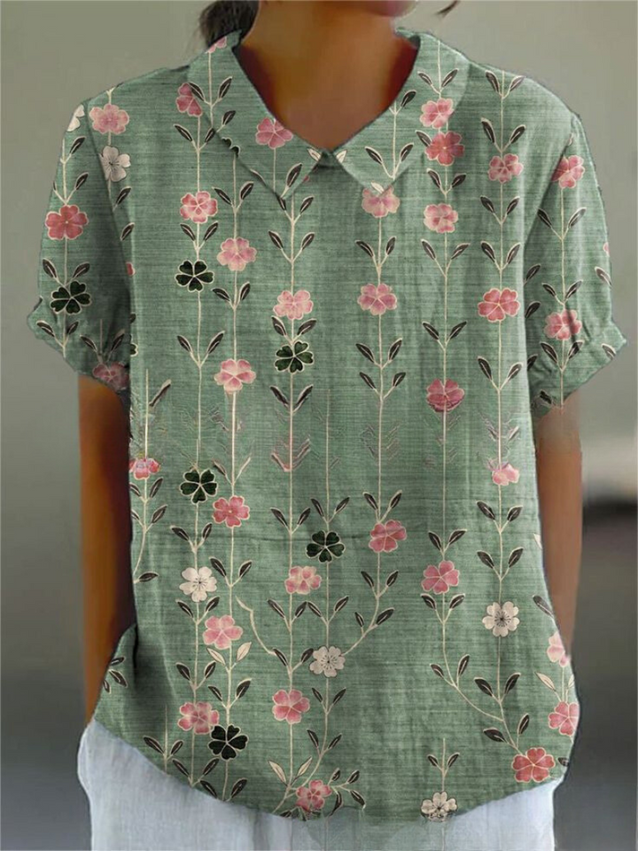  Model wearing a floral blouse with a lightweight and airy appearance on a plain background.