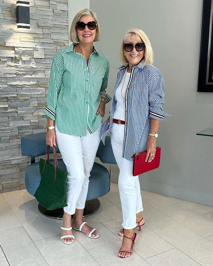 Two female model wearing a smart-casual striped shirt in a brick outdoor wall background.