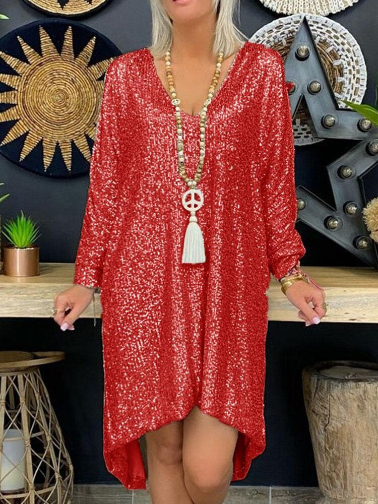  Woman wearing a glittering long sleeve dress displayed on a plain background.