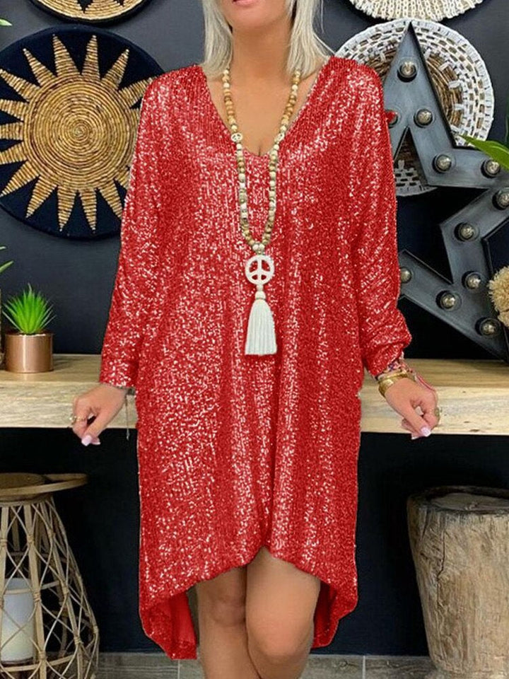  Woman wearing a glittering long sleeve dress displayed on a plain background.