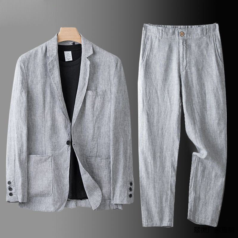  Man showcasing a relaxed two-piece summer suit on a plain background.