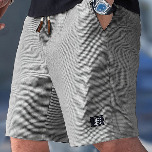 Men turning slightly displaying side pockets shorts on plain background