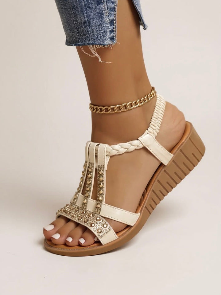 Stylish women’s embellished sandals worn by a model against a plain background.