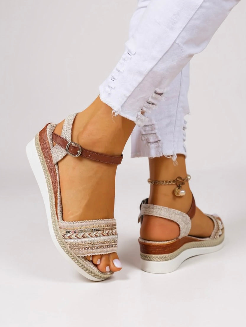 Embellished wedge sandals displayed on a model against a plain background.