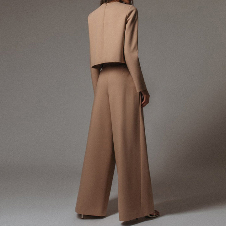 Woman posing in a matching top and wide-leg pants combination on a plain background.