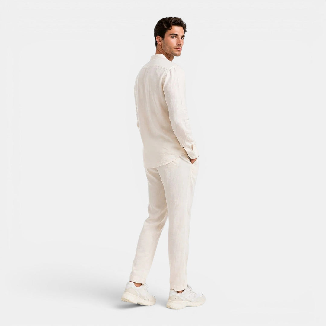  Man showcasing a relaxed matching shirt and pants set against a plain background.