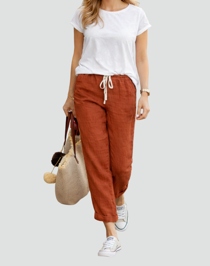  Woman wearing casual linen trousers with an adjustable waist on a plain background.