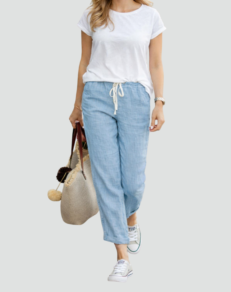  Female presenting loose-cut linen trousers with a relaxed appearance on a plain background.