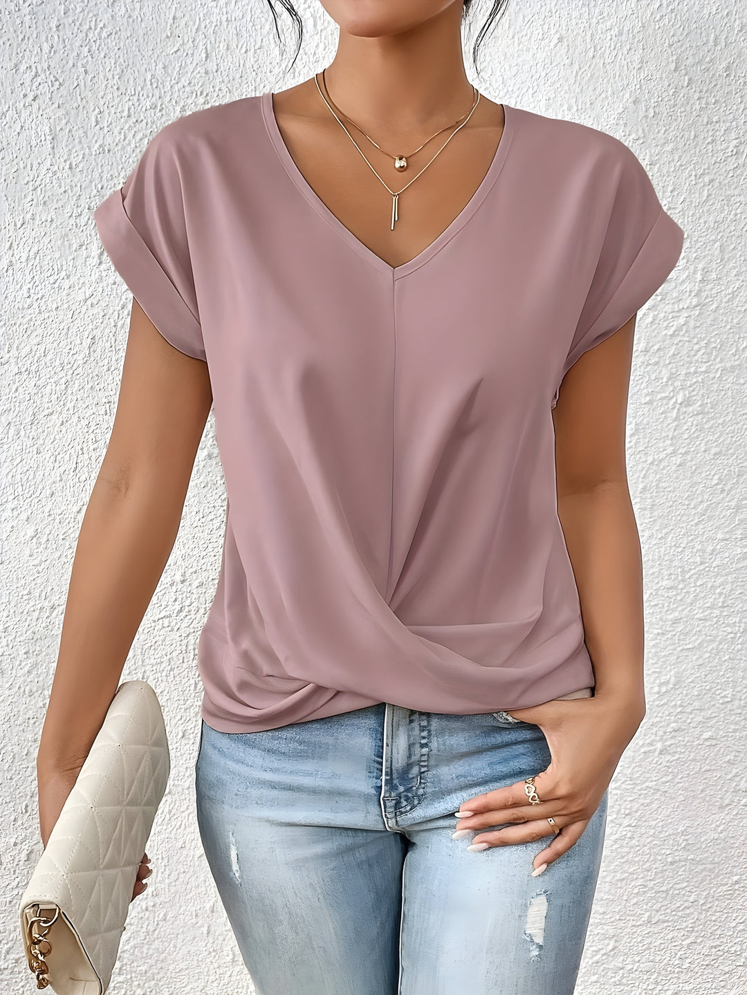 Women’s twist front V-neck top with model on a plain background.