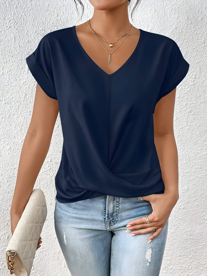 Elegant women’s V-neck top with twist front styling shown with model on clean background.