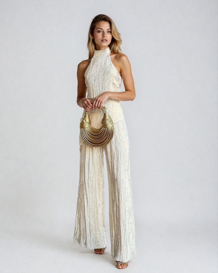 Female model wearing a beige pleated halter two-piece set on a plain background.