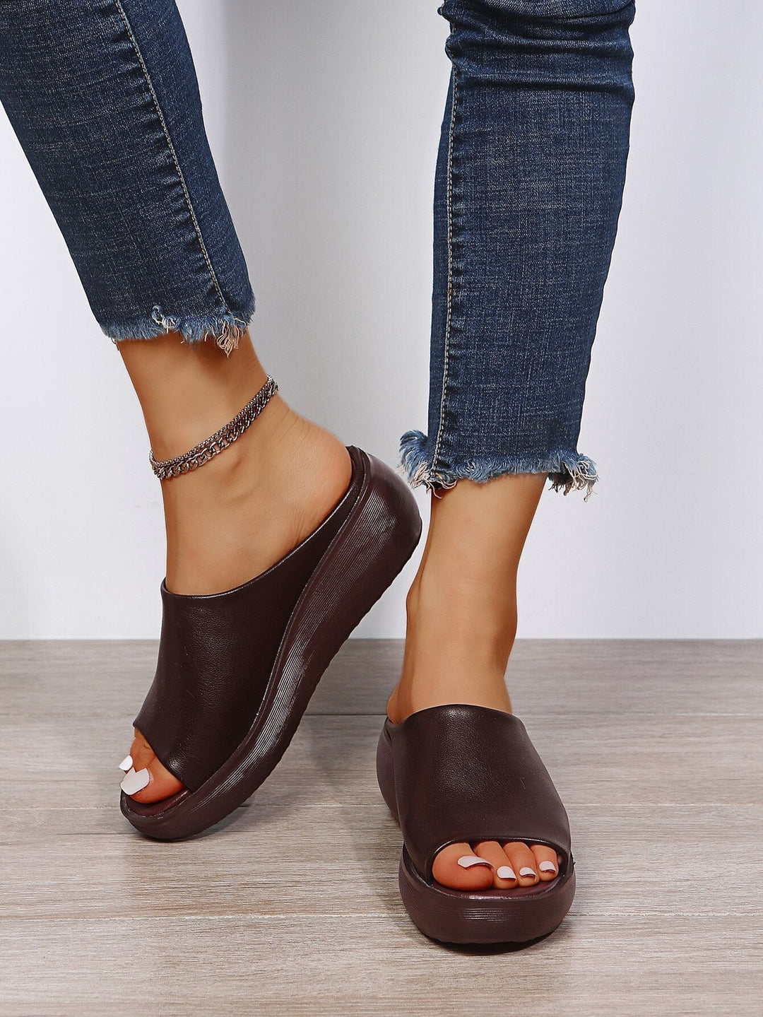 Close up of wedge sole sandals on woman plain background