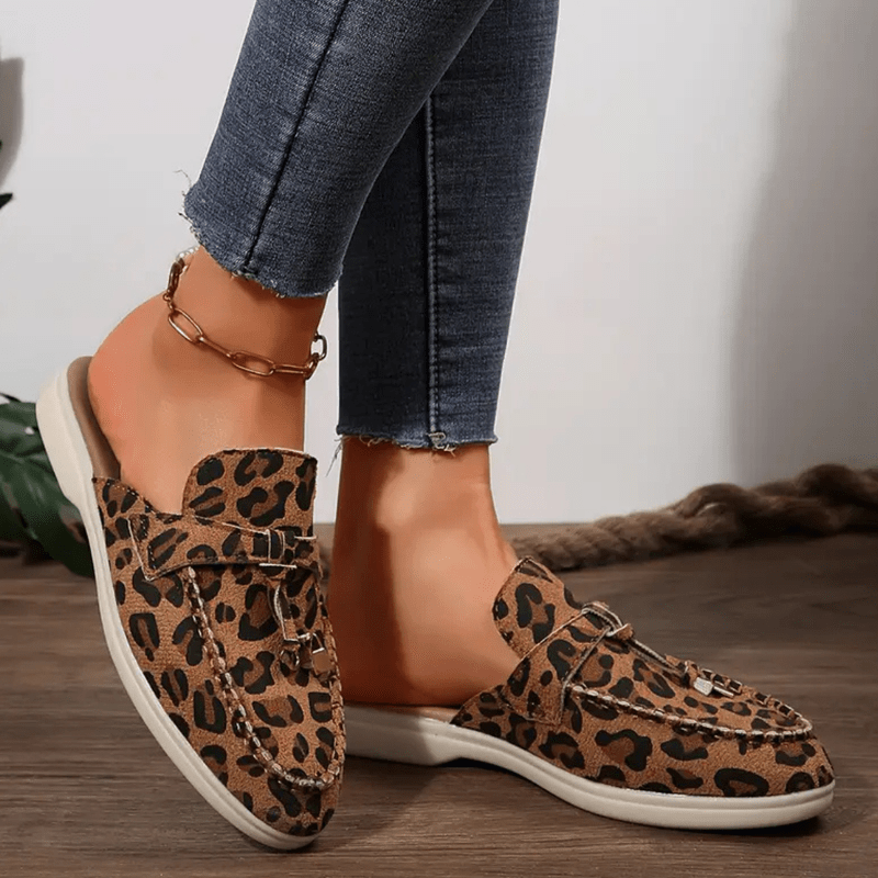 Foot model showing bold animal print loafers top angle view