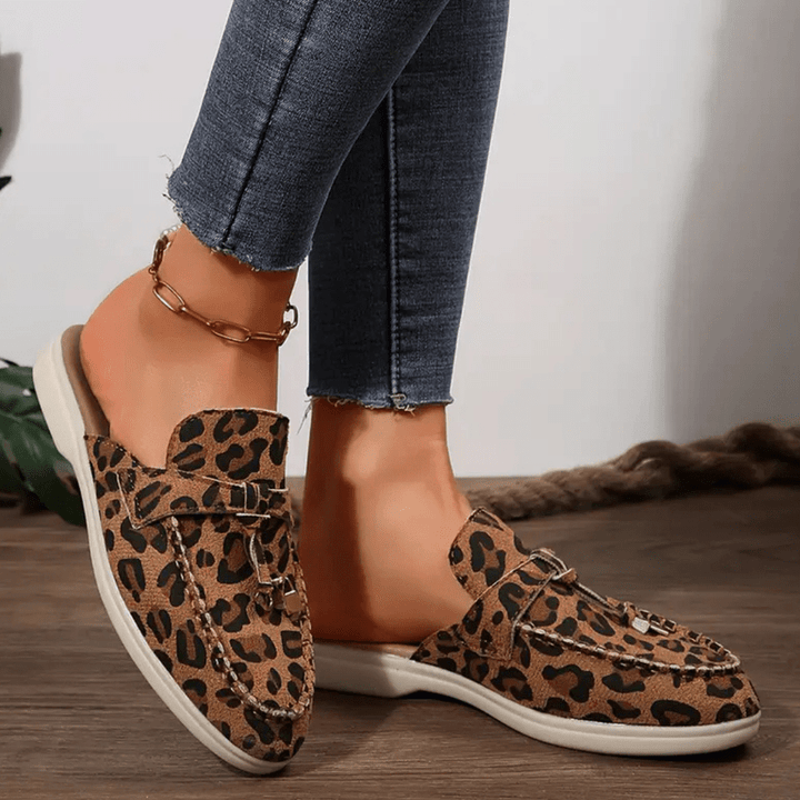 Foot model showing bold animal print loafers top angle view