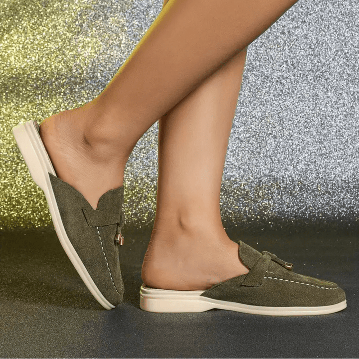 Side profile green flat shoes worn by foot plain background