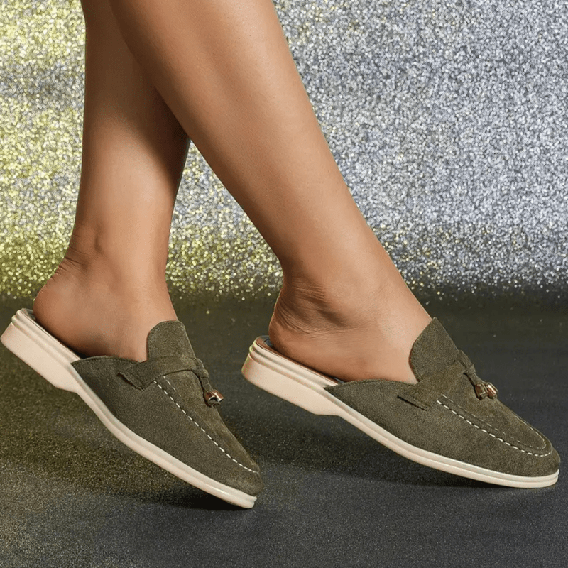 Side view green slip-on footwear worn on foot plain background