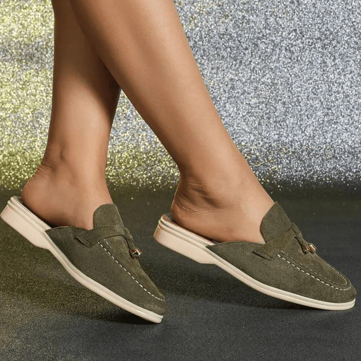 Side view green slip-on footwear worn on foot plain background