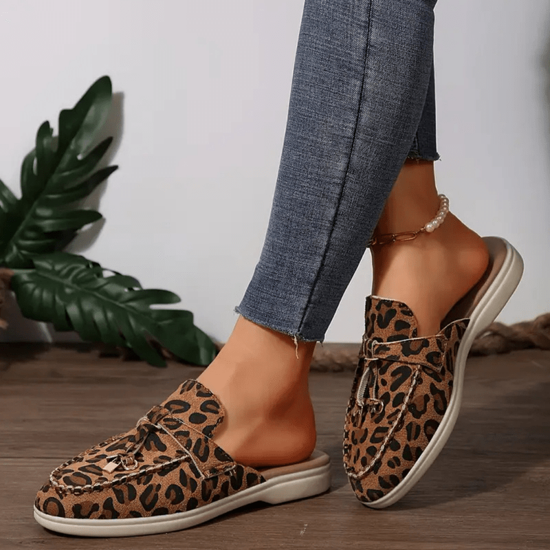 Close up foot wearing stylish loafers front angle plain background