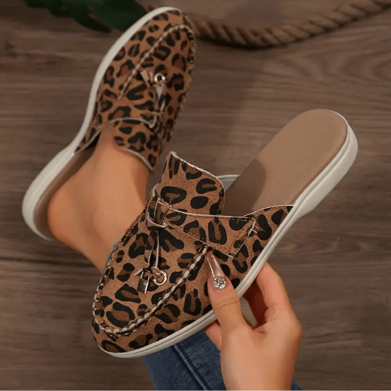 Foot posed wearing slip on loafers angled view minimal background