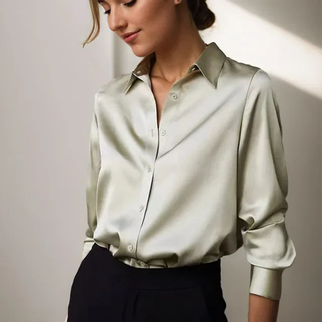 Woman model wearing a satin button front blouse against a plain background.