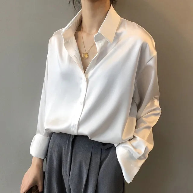 Elegant women’s satin button blouse displayed on a plain background.