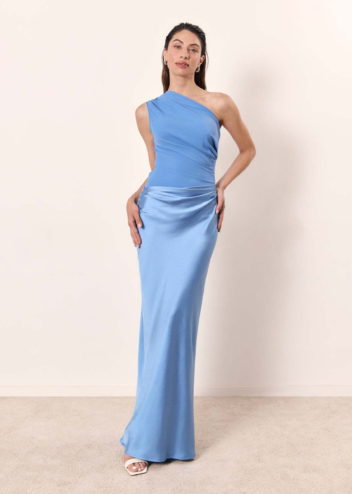 A female model showcases a long silhouette on beige background.