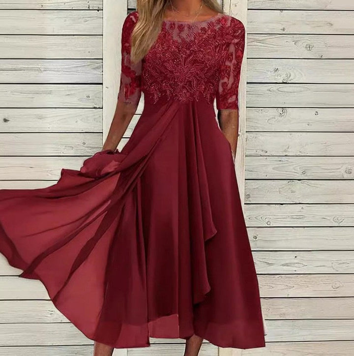 Female model wearing an ankle-length lace evening dress on a plain background.
