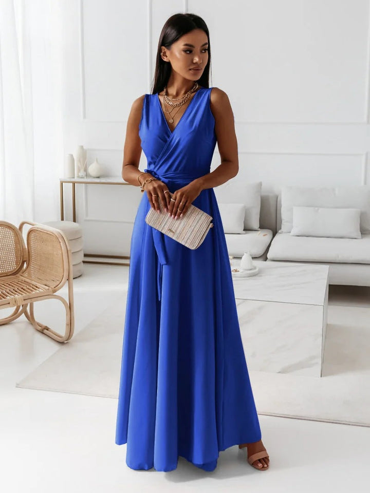 Woman in elegant summer dress posing gracefully inside living room.