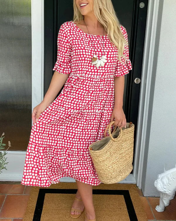 Pink dotted midi dress front view at doorway