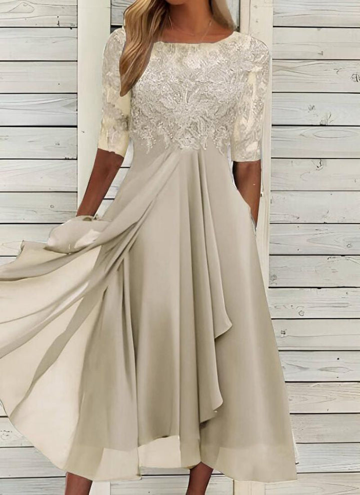 Female model wearing a sleeveless celebration dress with delicate lace detailing on a plain background.