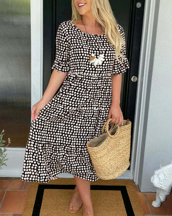 Black smocked waist dress on white doorway background