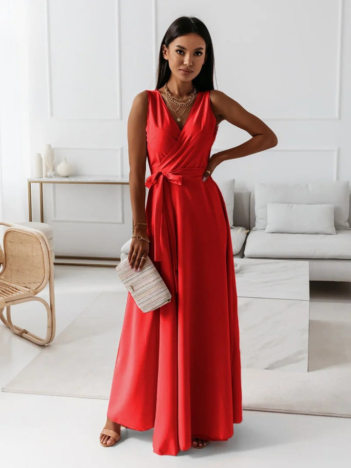 Female model wearing formal flowing dress, standing in living room.