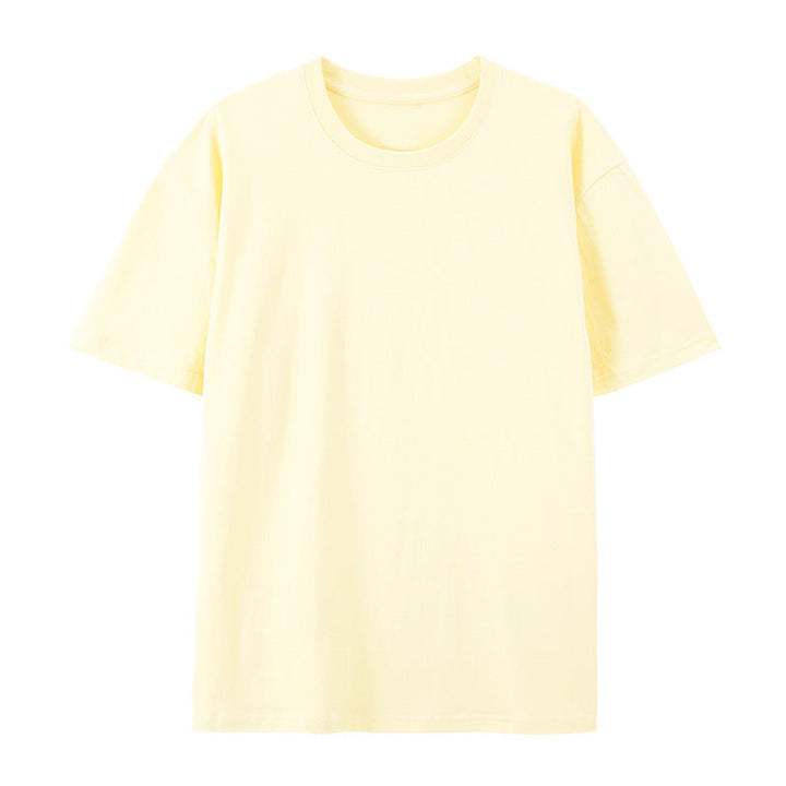Woman showcasing a loose-fit short-sleeve cotton T-shirt on a plain backdrop.

