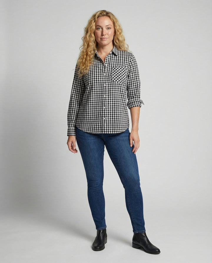 Woman in a relaxed plaid button-up shirt styled on a plain background.