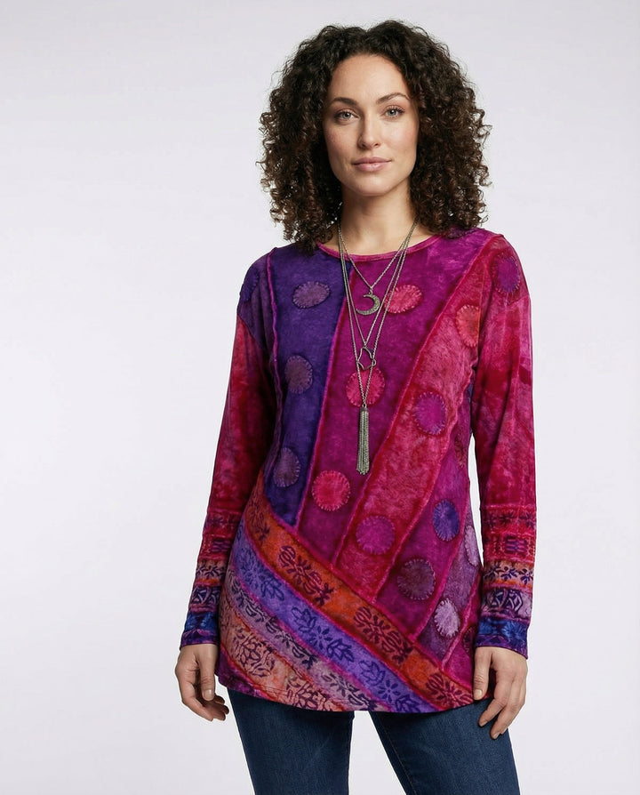 Female model wearing a colourful vintage tunic with a patterned design against a plain background.