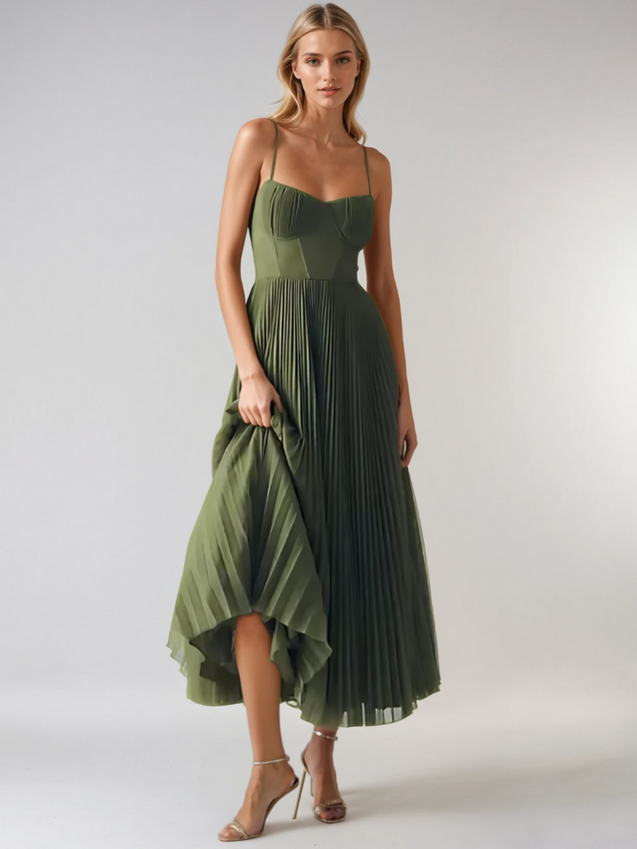 Woman wearing a graceful pleated formal look against a plain background.