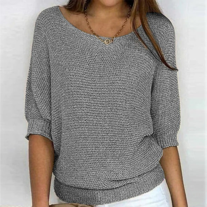Woman wearing soft knit top back angle plain background