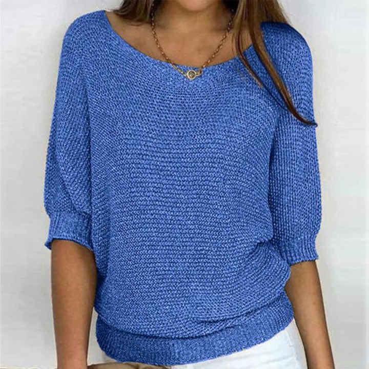 Female model showcasing batwing sleeve sweater front angle plain background
