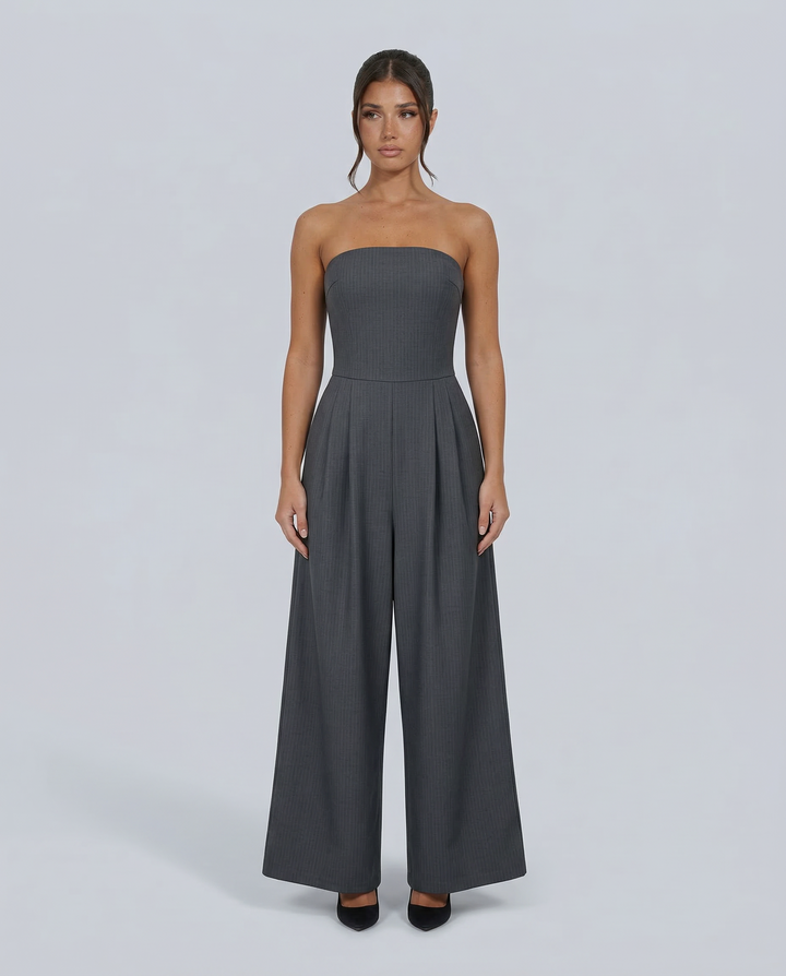 Woman wearing a fitted bodice jumpsuit with wide legs on a plain background.