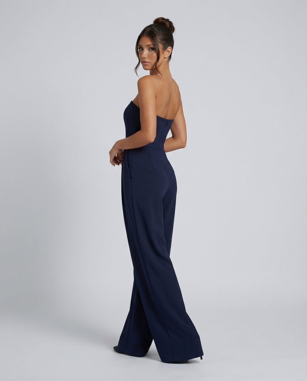 Female model in a sleeveless wide-leg jumpsuit against a plain background.