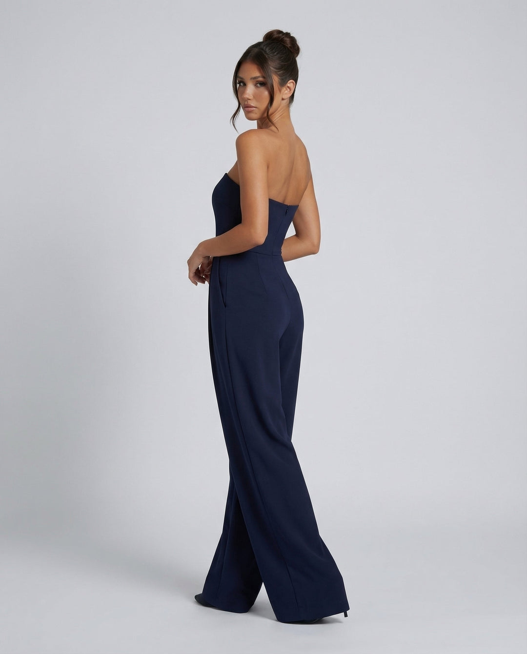 Female model in a sleeveless wide-leg jumpsuit against a plain background.