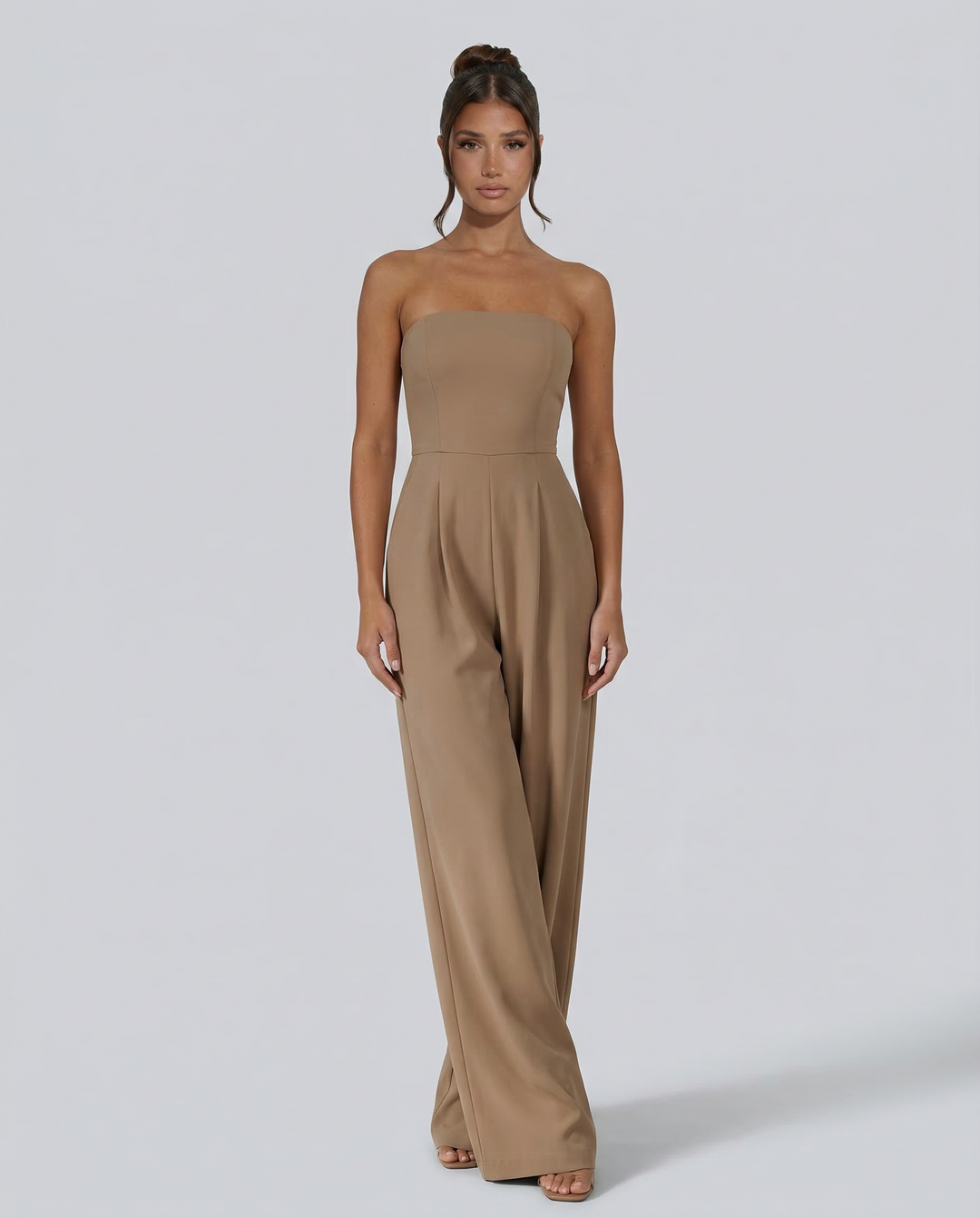 Woman in a black wide-leg jumpsuit against a plain background.