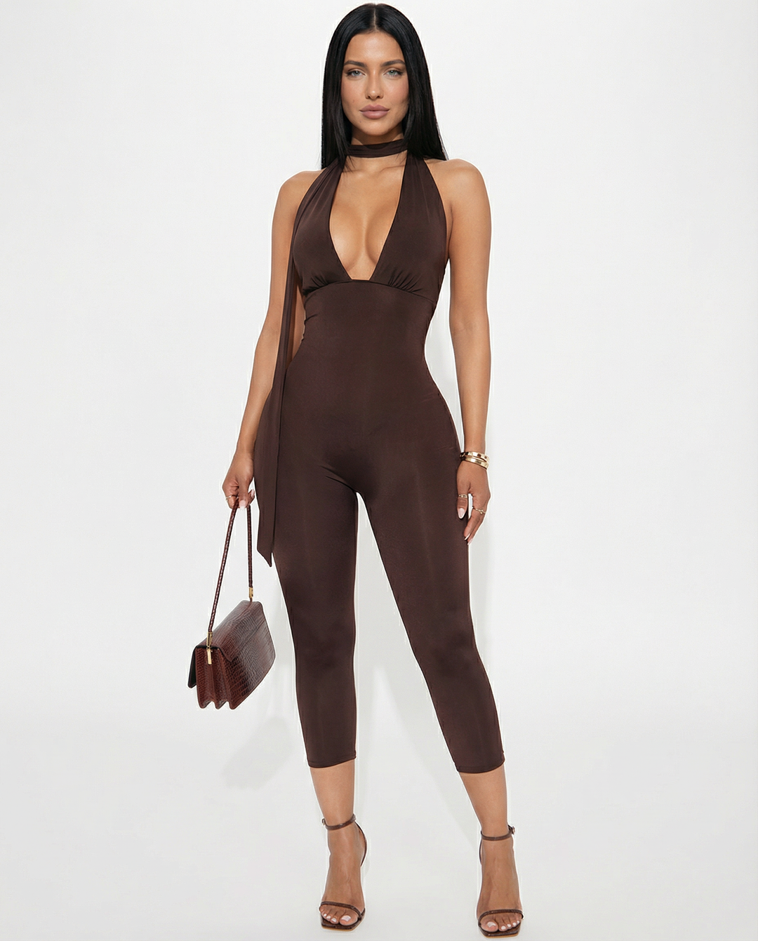 Model wearing a fitted open-back evening outfit on a plain background.