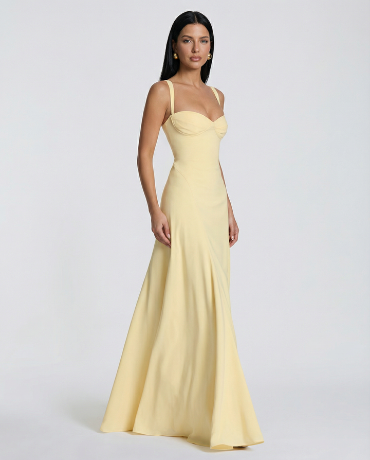 Female model wearing a yellow maxi dress with a sweetheart neckline and lace-up back against a plain background.
