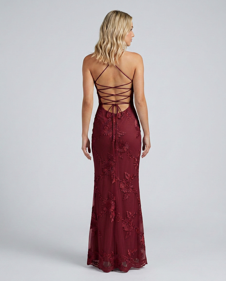 Female model in a sleeveless maxi dress with decorative floral accents and a close fit