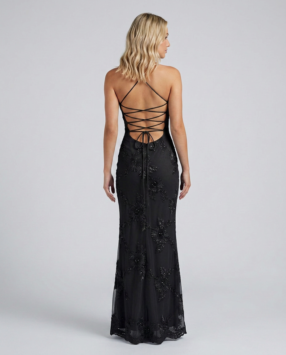 Female model in a long floral appliqué dress with a sculpted bodice and elegant shape.